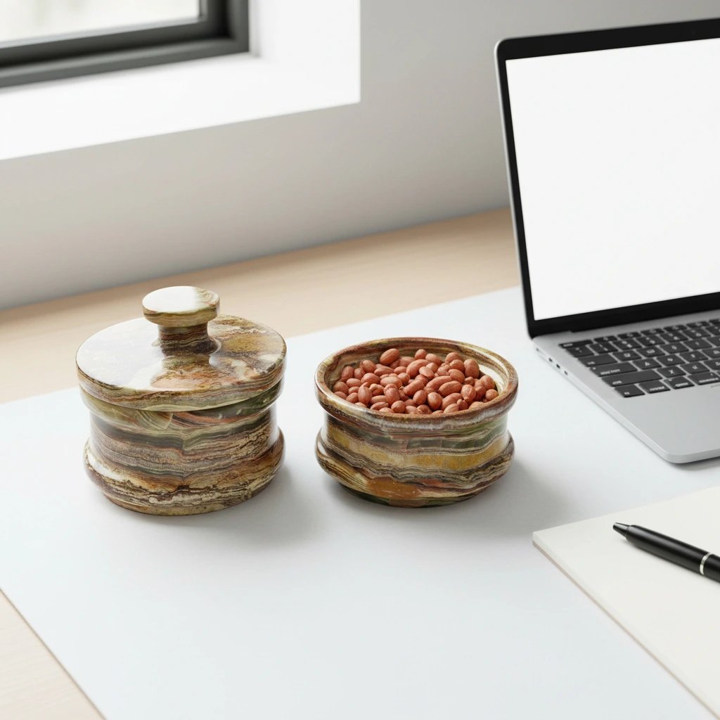 Handmade onyx marble candy containers on white desk next to laptop, one open with peanuts, showcasing dual storage functionality